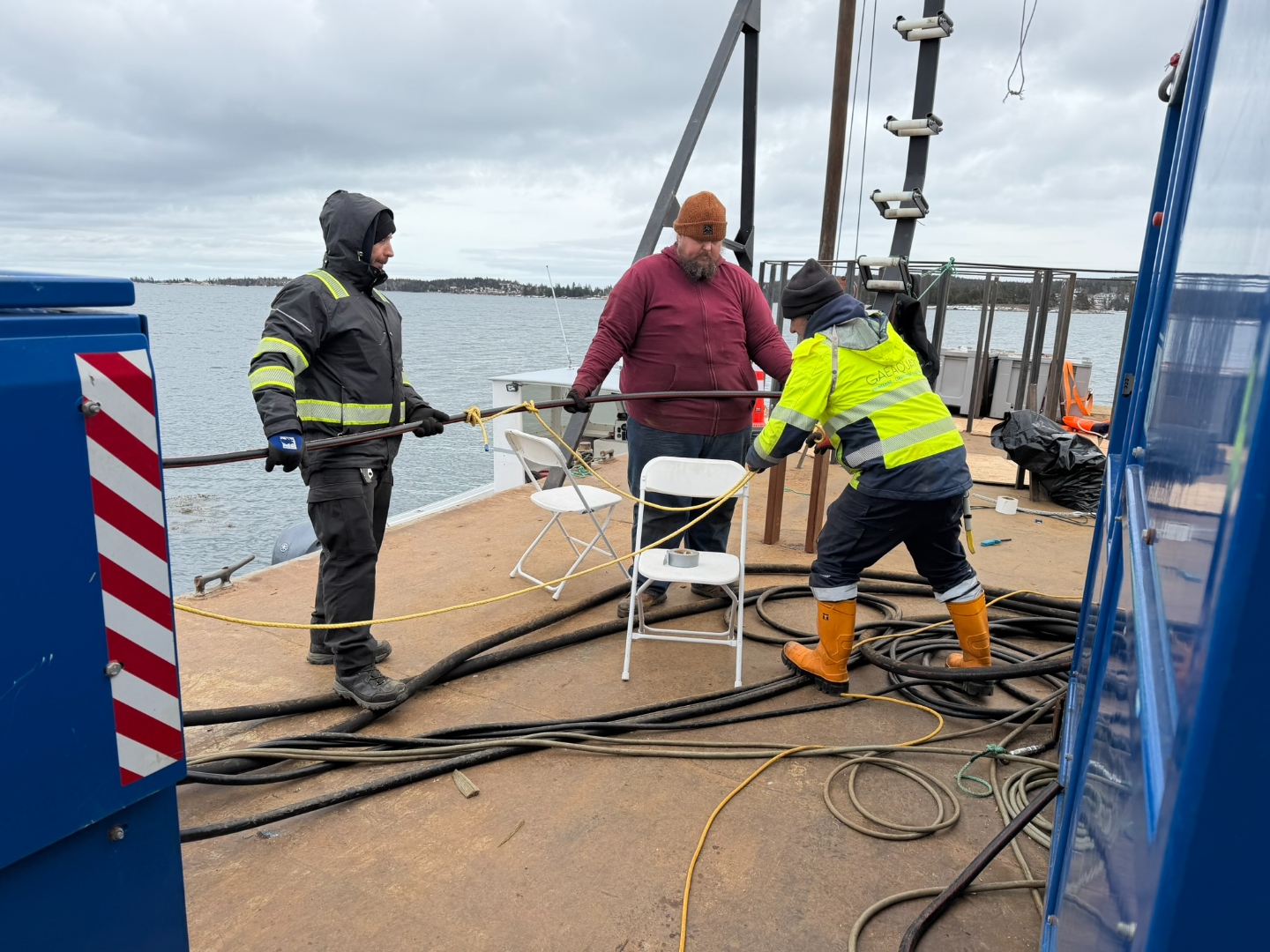 Crew handling submarine cable on deck